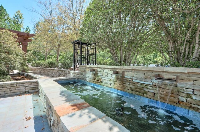 view of swimming pool with pool water feature