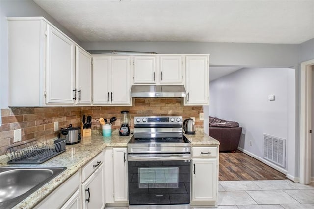 kitchen featuring tasteful backsplash, sink, white cabinets, and appliances with stainless steel finishes