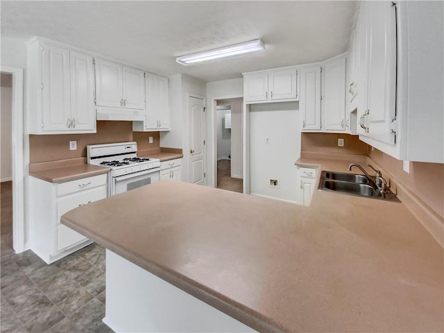 kitchen with white cabinetry, a sink, a peninsula, white range with gas stovetop, and under cabinet range hood