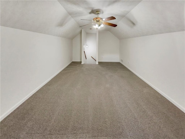 bonus room with lofted ceiling, carpet flooring, a ceiling fan, and baseboards