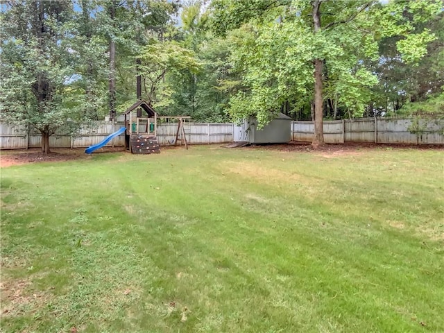 view of yard featuring a playground, an outdoor structure, a fenced backyard, and a shed