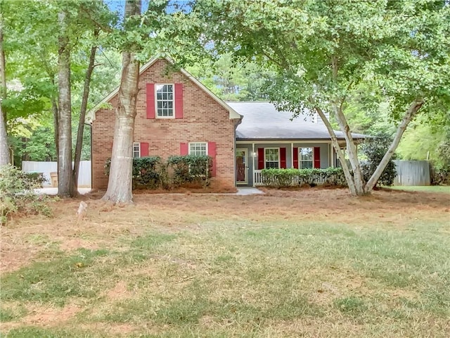 traditional-style house with a front yard, fence, and brick siding