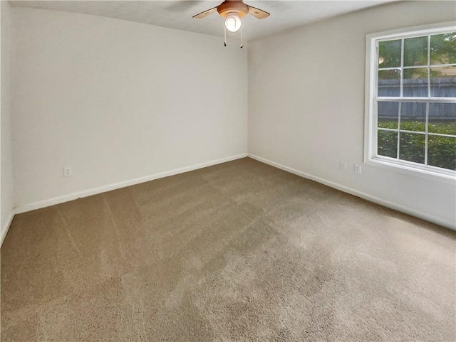 unfurnished room featuring carpet floors, ceiling fan, and baseboards