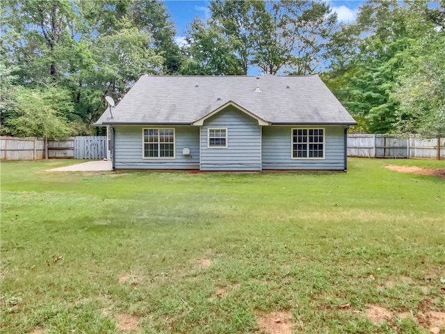 back of property featuring a lawn and a fenced backyard