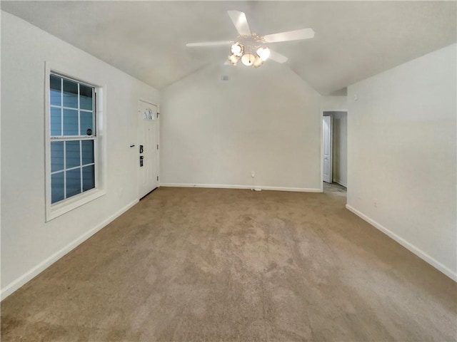 carpeted spare room with lofted ceiling, baseboards, and a ceiling fan