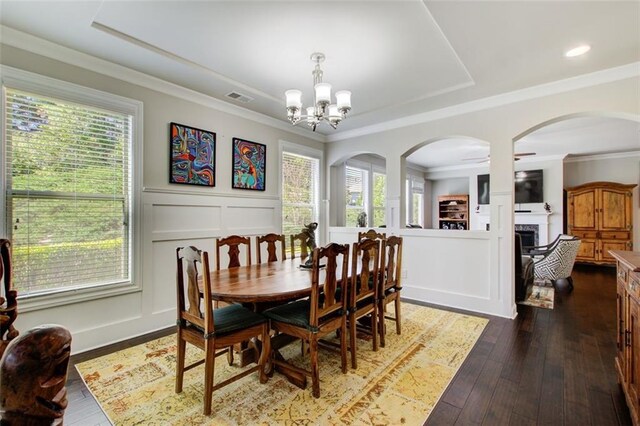 dining area featuring arched walkways, visible vents, a wealth of natural light, and a decorative wall