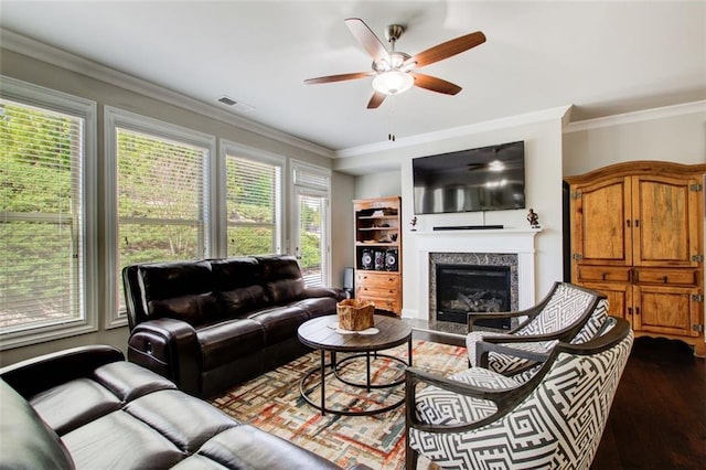 living area featuring a ceiling fan, visible vents, a healthy amount of sunlight, and dark wood-type flooring