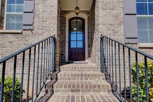 entrance to property featuring brick siding