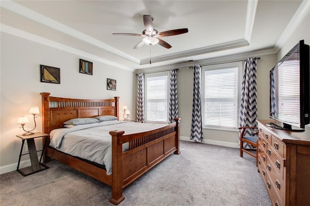carpeted bedroom featuring baseboards, a raised ceiling, crown molding, and ceiling fan