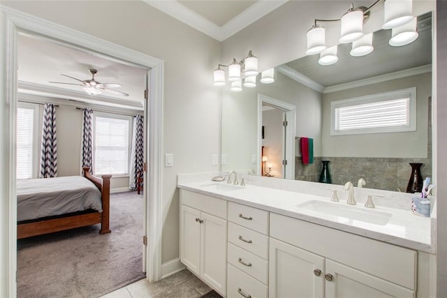 bathroom featuring crown molding, a sink, double vanity, and a healthy amount of sunlight