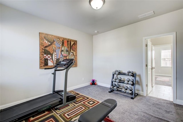exercise room with baseboards, visible vents, and carpet
