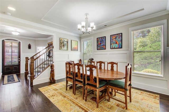 dining area with visible vents, a decorative wall, stairs, and a chandelier