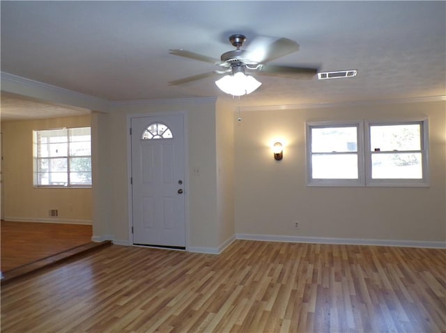 entrance foyer featuring ornamental molding, ceiling fan, and light hardwood / wood-style flooring