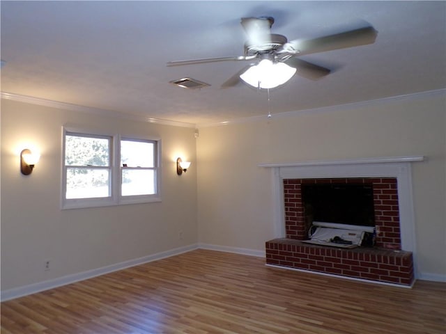 unfurnished living room featuring wood-type flooring, ornamental molding, ceiling fan, and a fireplace