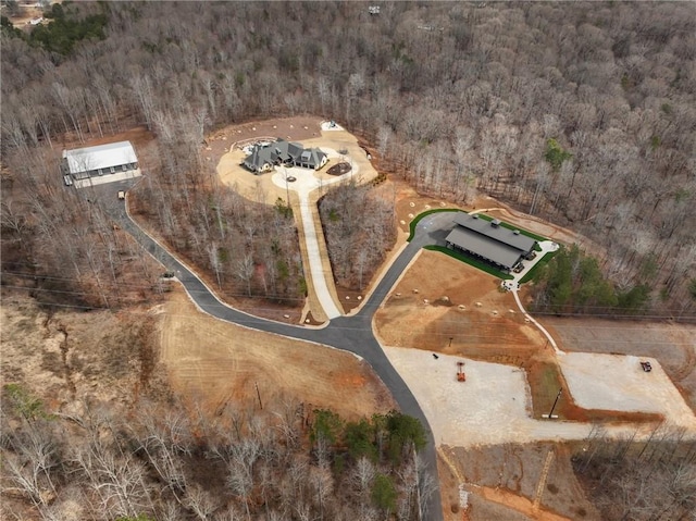 bird's eye view with a wooded view