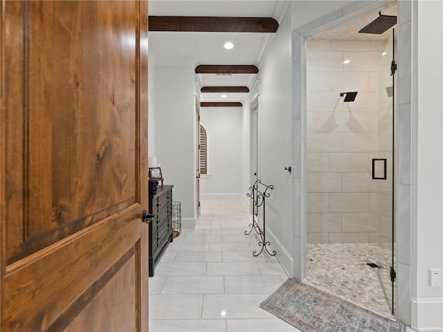 bathroom featuring tile patterned floors, beamed ceiling, tiled shower, crown molding, and baseboards