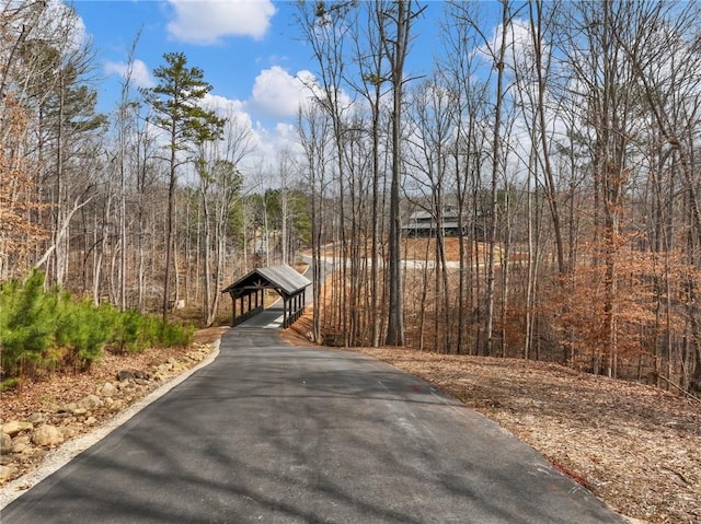 view of street featuring a forest view and driveway