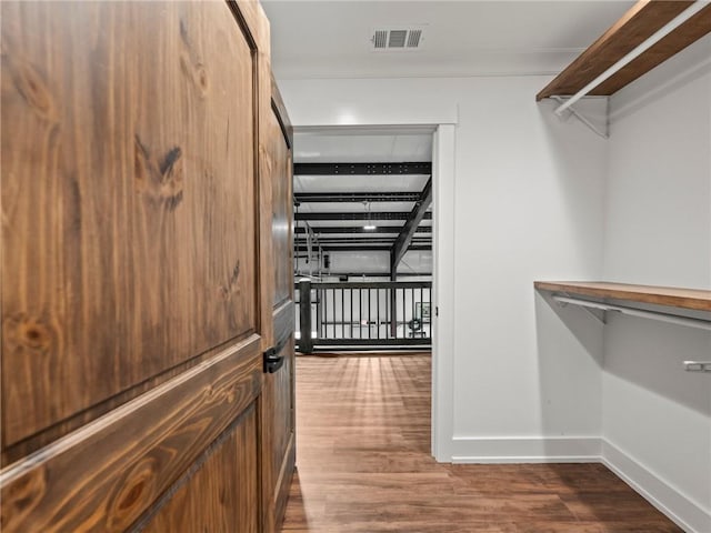 walk in closet with visible vents and wood finished floors