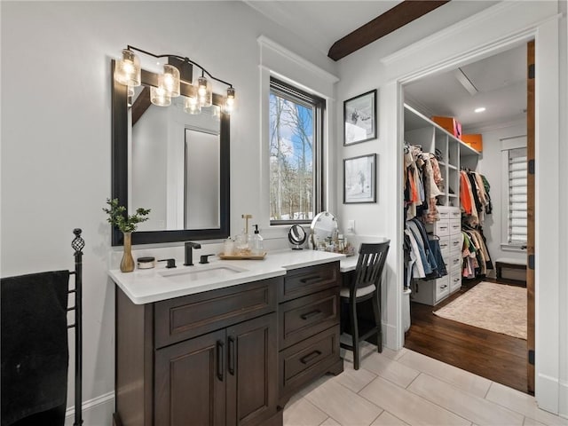 bathroom featuring a spacious closet, tile patterned floors, vanity, and ornamental molding