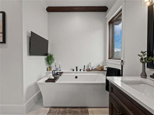 full bath featuring vanity, baseboards, and a freestanding tub