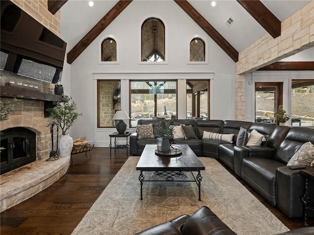 living area with visible vents, dark wood finished floors, beamed ceiling, a fireplace, and high vaulted ceiling