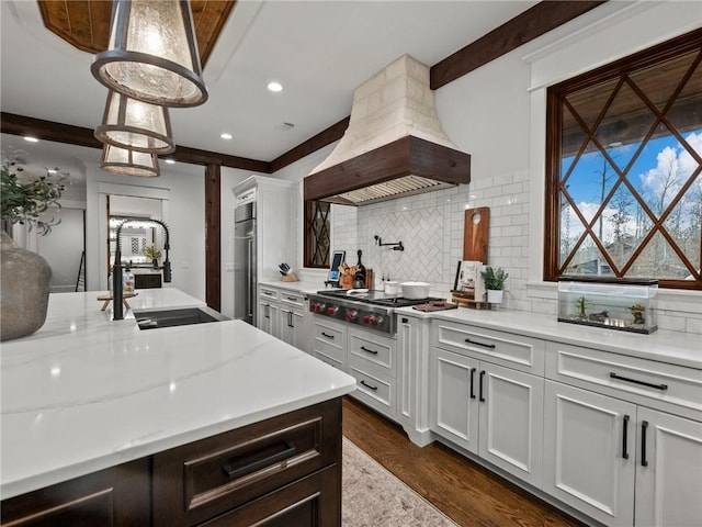 kitchen with island exhaust hood, a sink, dark wood-style floors, decorative backsplash, and stainless steel gas cooktop