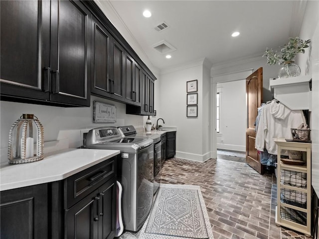 laundry area with visible vents, baseboards, brick floor, cabinet space, and independent washer and dryer