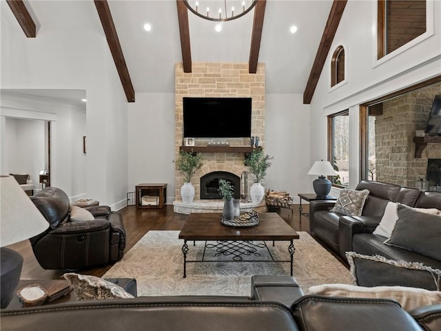 living area featuring a stone fireplace, an inviting chandelier, beamed ceiling, and wood finished floors