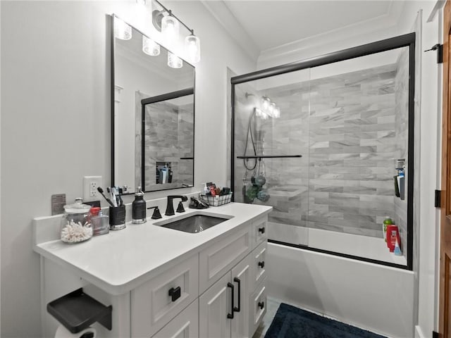 bathroom with combined bath / shower with glass door, vanity, and ornamental molding