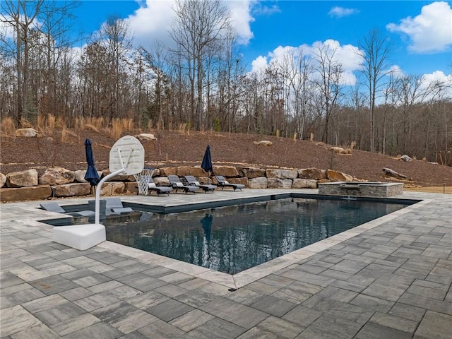 pool featuring an in ground hot tub and a patio area