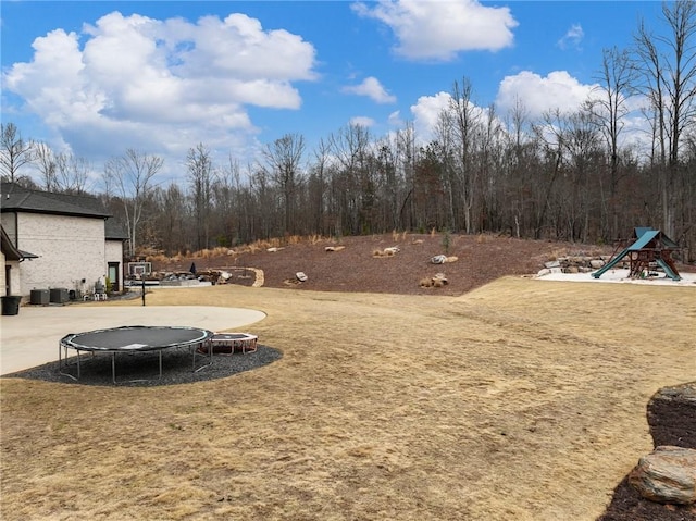 view of yard with a trampoline and playground community