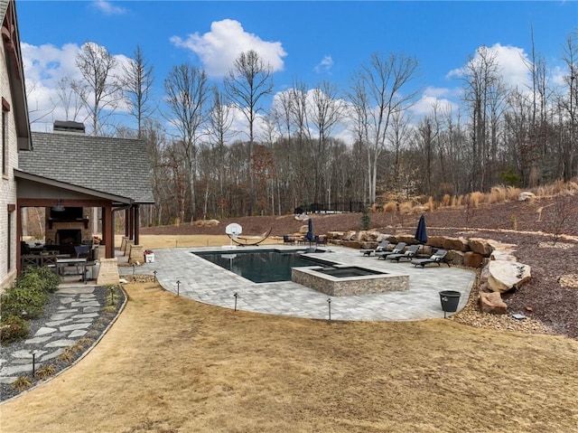 outdoor pool featuring a patio area, a lawn, and an in ground hot tub