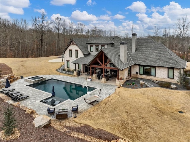 outdoor pool featuring a patio and an in ground hot tub