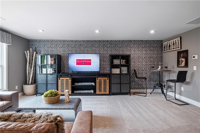 carpeted living room with brick wall