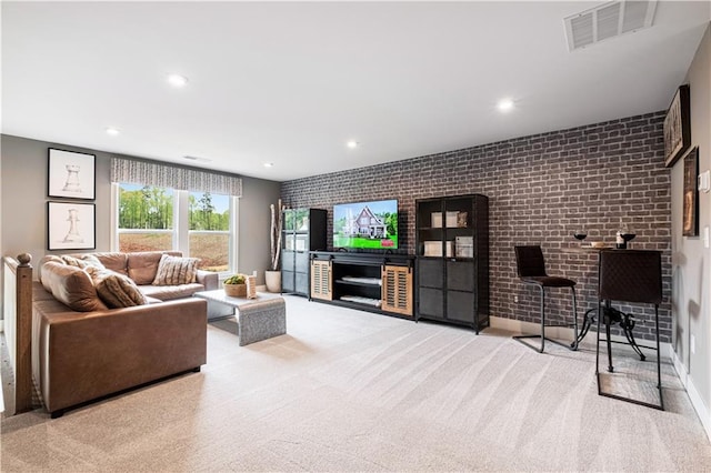 carpeted living room featuring brick wall