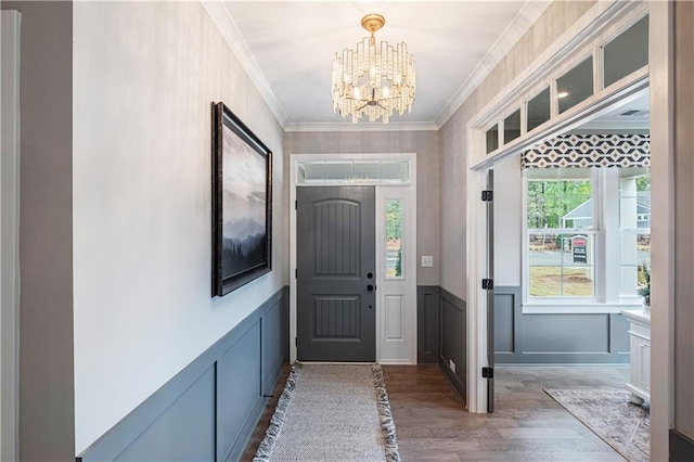 entryway featuring an inviting chandelier, dark hardwood / wood-style flooring, and crown molding