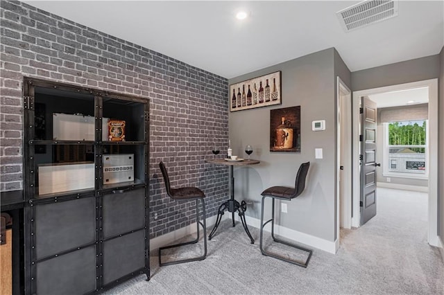 sitting room featuring light carpet and brick wall