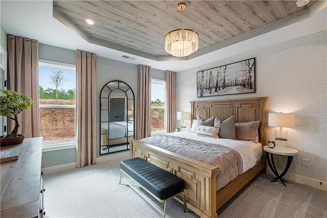 carpeted bedroom with wooden ceiling, multiple windows, a tray ceiling, and an inviting chandelier