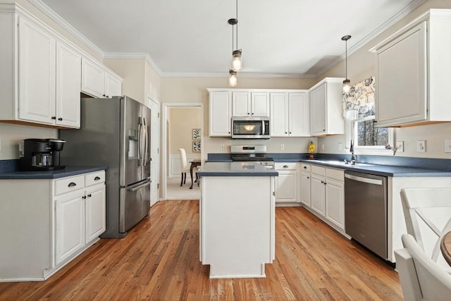 kitchen with dark countertops, white cabinets, appliances with stainless steel finishes, and a center island