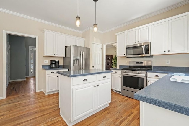 kitchen with pendant lighting, a kitchen island, dark countertops, white cabinetry, and appliances with stainless steel finishes