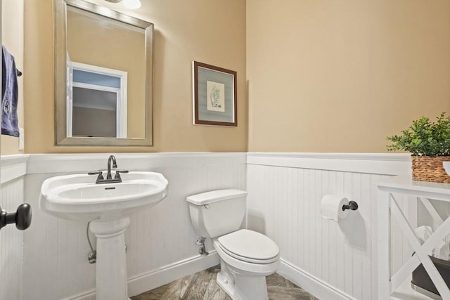 half bath with wainscoting and toilet