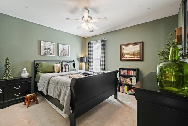 bedroom with visible vents, light colored carpet, and a ceiling fan