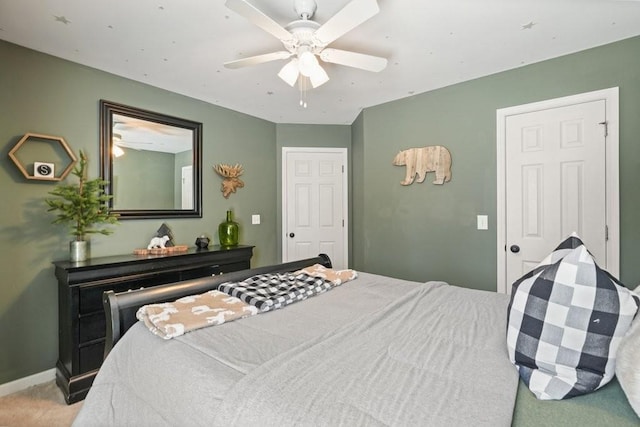 bedroom with baseboards, light colored carpet, and a ceiling fan