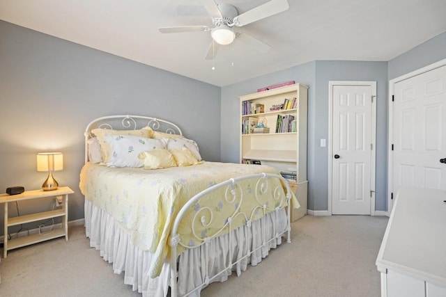 bedroom featuring baseboards, light colored carpet, and ceiling fan