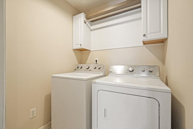 washroom with washing machine and clothes dryer and cabinet space