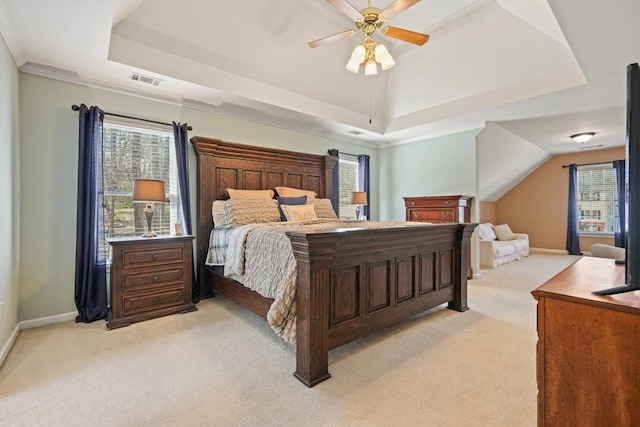 bedroom with a tray ceiling, light colored carpet, visible vents, and baseboards