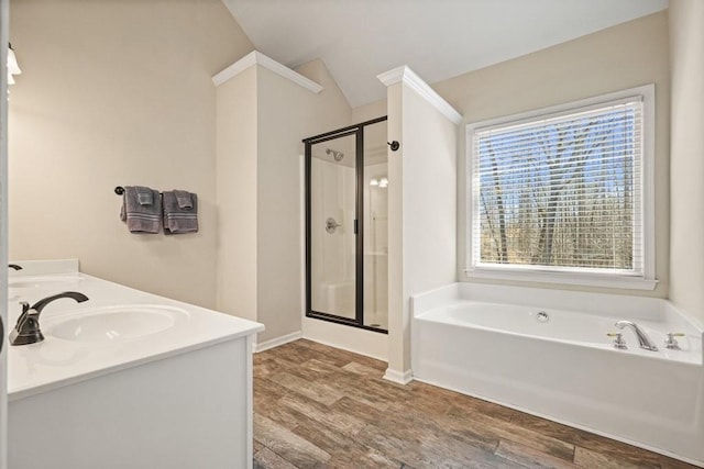 full bath with a garden tub, a sink, wood finished floors, a shower stall, and double vanity