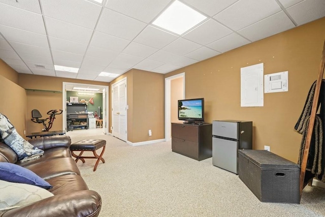 carpeted living room featuring electric panel, a drop ceiling, and baseboards