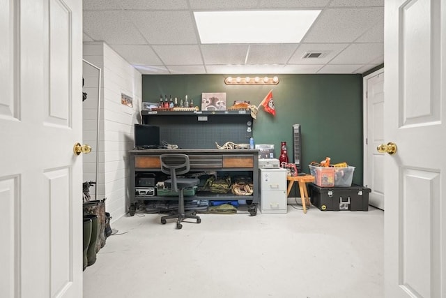 office featuring a paneled ceiling, visible vents, and concrete floors