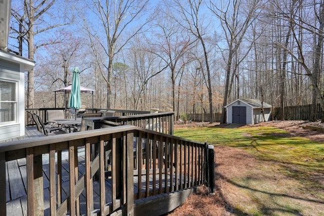 wooden terrace with outdoor dining area, an outbuilding, and a storage shed